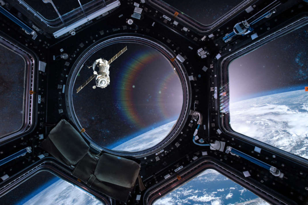 View from a porthole of space station on the Earth background. Elements of this image furnished by NASA
